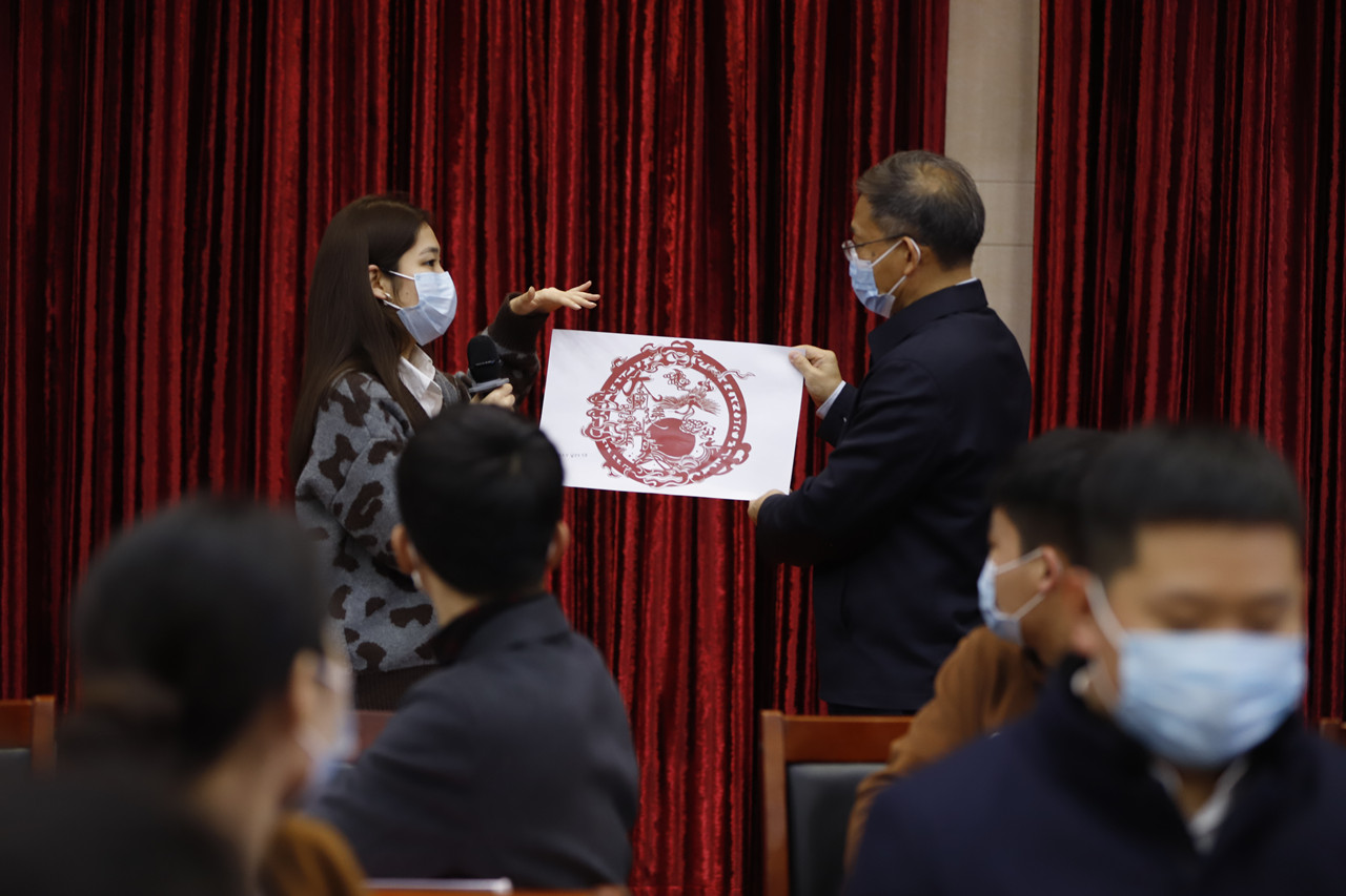 7c5782af7a4340cfb6835a61dd35fef9.jpg 秀丽向公司领导介绍剪纸作品_副本.jpg